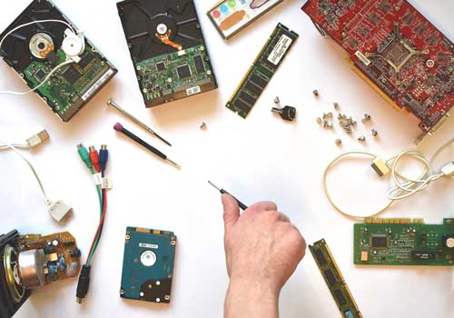 Man with various computer parts for computer repair.