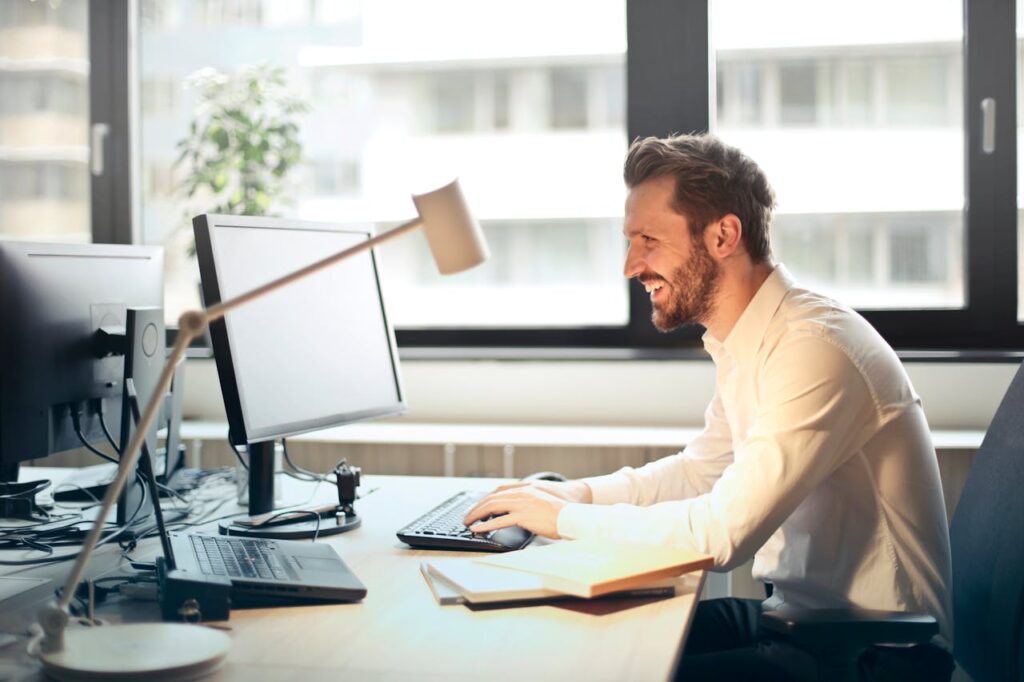 Man smiling and looking at his computer.